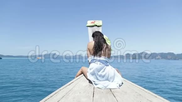 美丽的女人坐在泰国的船上快乐的微笑张开手年轻的女孩享受风视频的预览图
