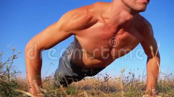 健身强壮的人做俯卧撑在外面拍自然慢动作视频的预览图