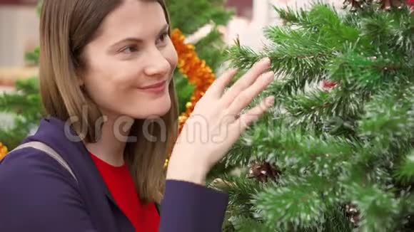 快乐快乐的女人在商场买圣诞装饰品女性选择人造圣诞树视频的预览图