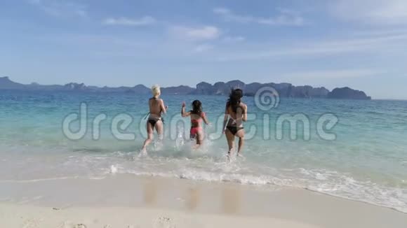 在海滩后景的水中奔跑的女孩女子团体起飞比基尼视频的预览图