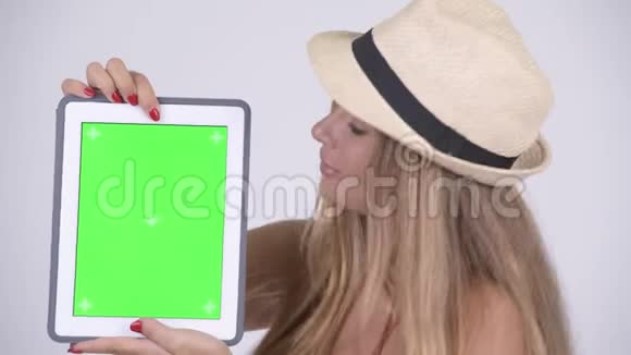 一位年轻美丽的旅游女伴展示数码平板电脑视频的预览图