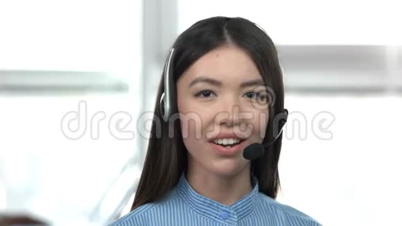 白种人年轻的亚洲女孩用耳机说话视频的预览图