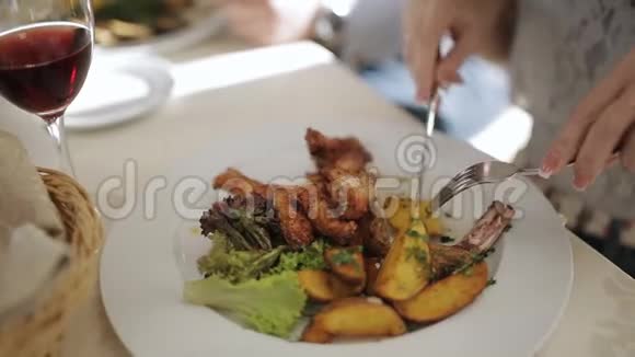 在餐馆里用刀叉吃饭的女孩在餐馆吃午饭的女人视频的预览图