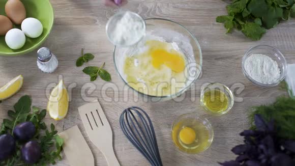 厨师用鸡蛋在玻璃碗上筛面粉然后揉捏俯视视频的预览图