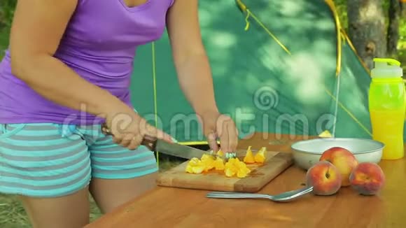 一个年轻的女人正在木板上编织一个橘子做水果沙拉视频的预览图