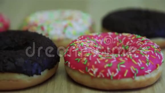 木桌上鲜艳的开胃甜甜圈特写视频的预览图