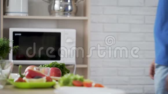 男人从餐桌上拿着新鲜苹果想吃健康的零食作为午餐视频的预览图