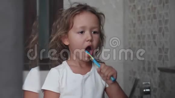 小女孩正在浴室里用牙刷刷牙视频的预览图