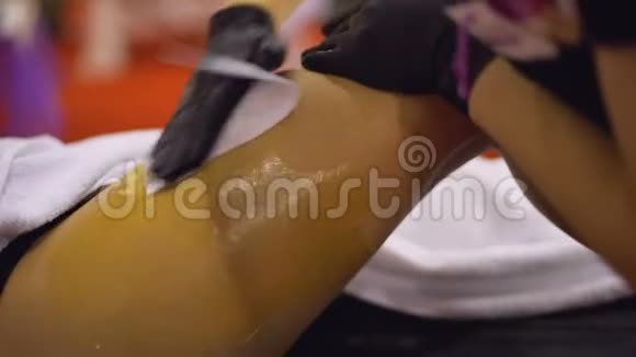 美容师在美容院给女性腿部打蜡皮肤护理程序美容视频的预览图