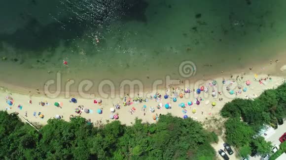 海滩湾的高空俯视图雨伞沙子和海浪暑假视频的预览图