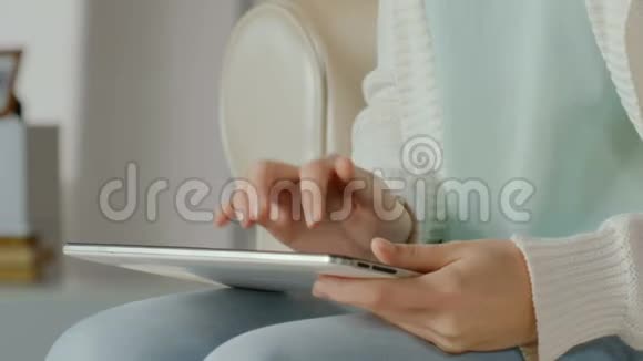 满意的女性客户在平板电脑上打字购买评论在家工作视频的预览图