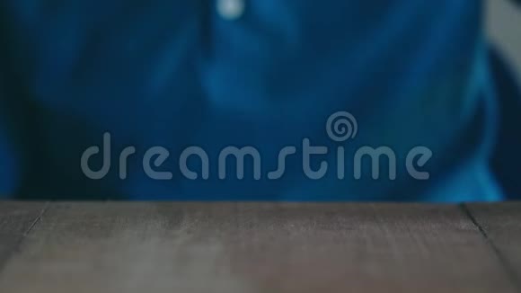 穿着蓝色衬衫的女人正在棕色的木桌上堆硬币视频的预览图