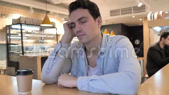 睡在咖啡馆里的疲惫青年视频的预览图