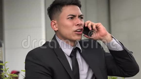 愤怒英俊的拉美裔成年男子用电话视频的预览图