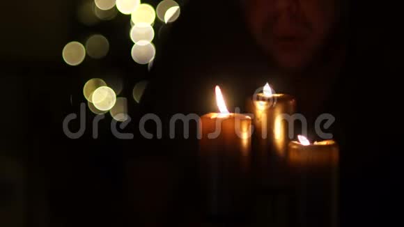 无名氏吹灭了三根厚厚的蜡烛深色背景灯光模糊你可以看到黑烟从视频的预览图