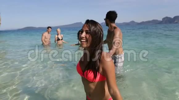 快乐的微笑女人牵着男人的手人们从海滩上的水中来游客在海上度假视频的预览图