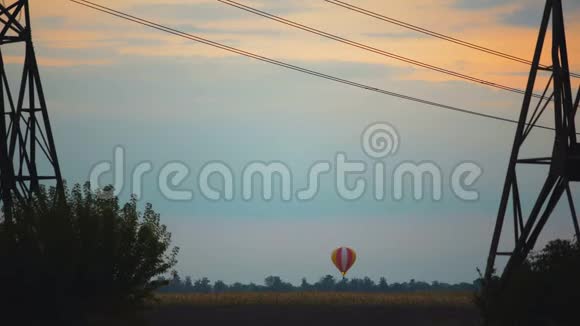 令人叹为观止的彩色热气球在日落时飞过田野视频的预览图