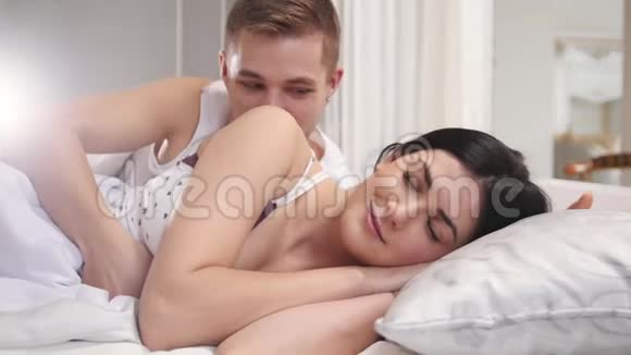 深情的男人通过吻醒了熟睡的女孩年轻的夫妇醒来视频的预览图