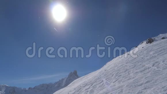 在明亮的阳光下带着光晕和一架飞行飞机观看冬天的雪山视频的预览图