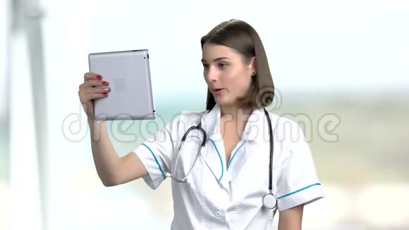 年轻的女医生通过互联网交谈视频的预览图