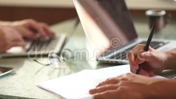 两个商人在工作特写的手和笔记本电脑一个人用纸画一个计划训练同事视频的预览图