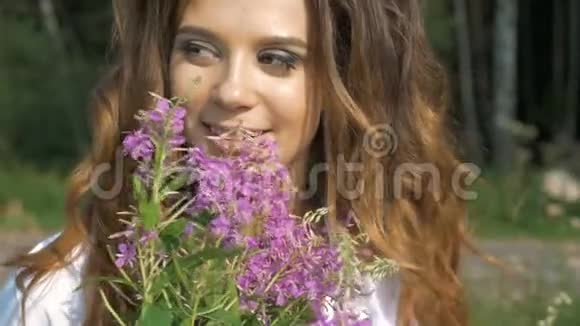 一个美丽的女孩吹在野花的种子上野花向不同的方向飞去慢动作视频的预览图