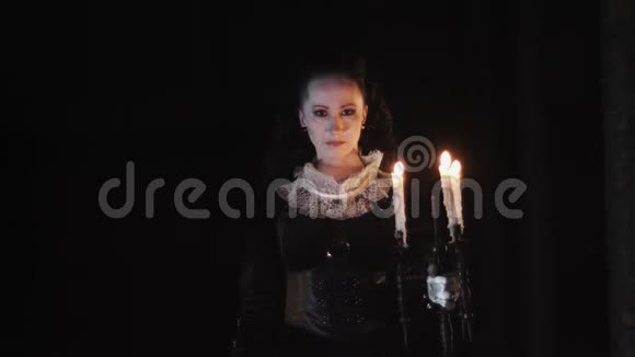 神秘的女人穿着维多利亚的衣服站在黑暗的房间里戴着糖果视频的预览图