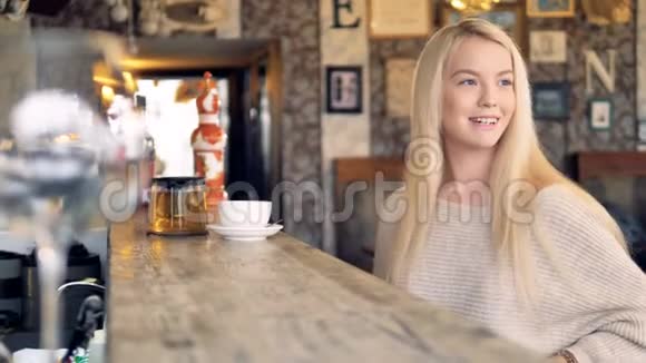 一个年轻漂亮的女人用智能手机支付她的茶并感谢服务器4K视频的预览图