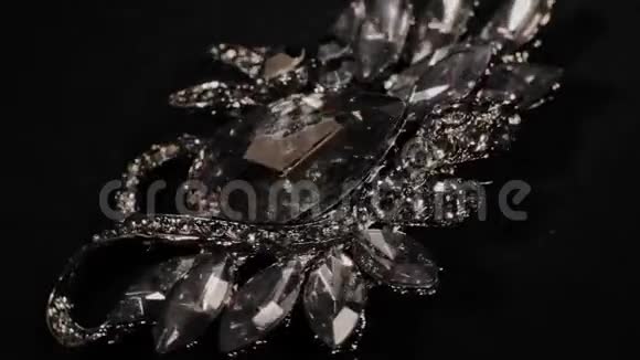 在一个黑色的旋转支架上用石头打胸针高级珠宝宏视频的预览图
