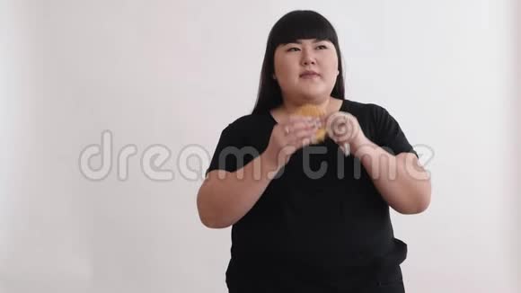 亚洲貌美的女孩吃一个汉堡享受这种味道年轻人的饮食不健康视频的预览图
