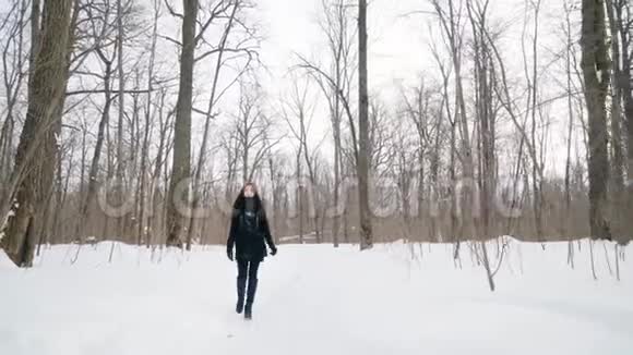 一个快乐的女孩正沿着冬天的公园散步视频的预览图