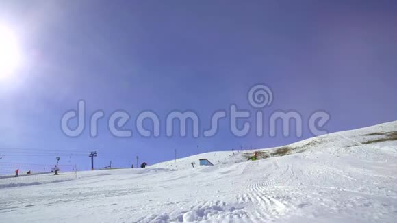 一个人骑在滑雪板上的斜坡上表演一个把戏阿尔卑斯山的滑雪胜地视频的预览图