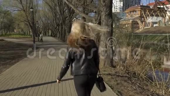 穿着黑色牛仔裤的金发女孩走路视频的预览图
