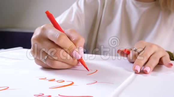 书法学生练习在画布上用红色标记写单词爱创意艺术家自由职业者视频的预览图