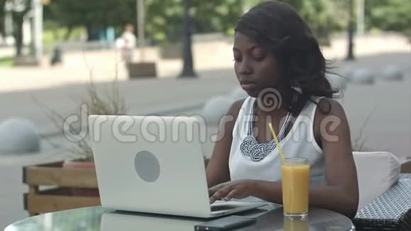 一位在户外工作的非裔美国妇女正在喝酒视频的预览图