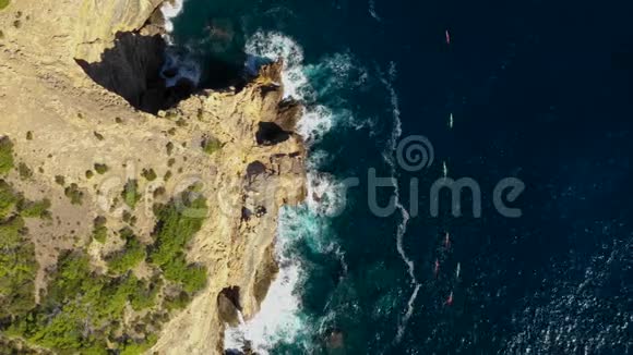 一群运动员在伊比萨岛东部海角的皮艇里游泳Balear群岛的空中景观视频的预览图