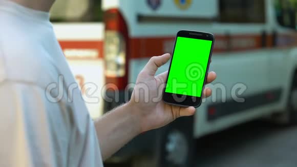 男子手持智能手机背景救护车在线医疗咨询视频的预览图