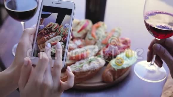 餐饮拍照女人看手机屏幕上的照片视频的预览图