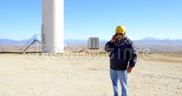 男工程师在风电场用手机通话视频的预览图