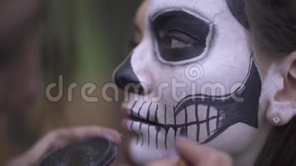万圣节化妆师将化妆应用于女孩的脸视频的预览图