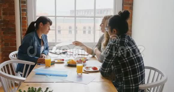 女商人一边吃早餐一边讨论文件视频的预览图