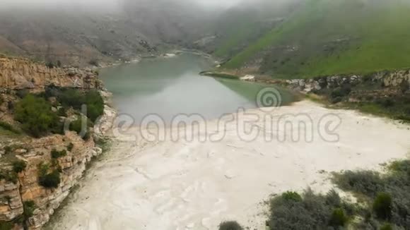 在阴天和雾天的丘陵中鸟瞰山绿松石湖北高加索的地貌视频的预览图