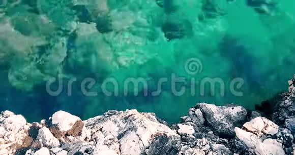 热带加勒比海海滩的顶部是绿色和蓝色的海洋有金色的沙子和岩石假日缓慢的海洋运动放松和视频的预览图