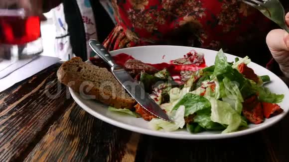 人们在白盘上吃有沙拉的开胃炒肉视频的预览图