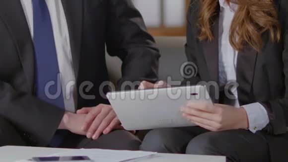 女士向同事展示平板电脑屏幕专业建议合同细节视频的预览图
