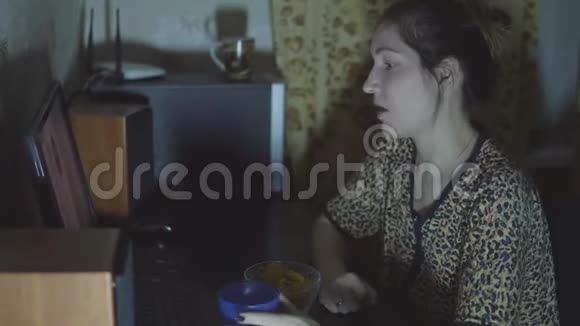 年轻女孩在电脑前看电影吃薯条视频的预览图