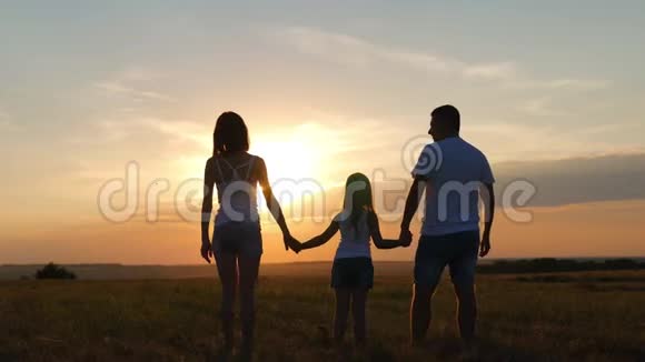 剪影和爸爸妈妈一起快乐的孩子日落时分的家人夏天我们是幸福的家庭的概念视频的预览图