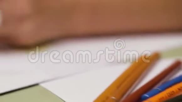 女孩用黑色铅笔左撇子画在纸上用慢镜头细看视频的预览图