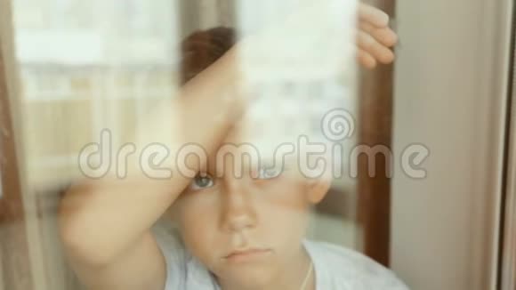 一个悲伤的孩子望着窗外视频的预览图