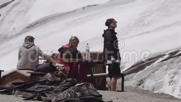 拍摄人员在山上露营地的餐桌上放松视频的预览图
